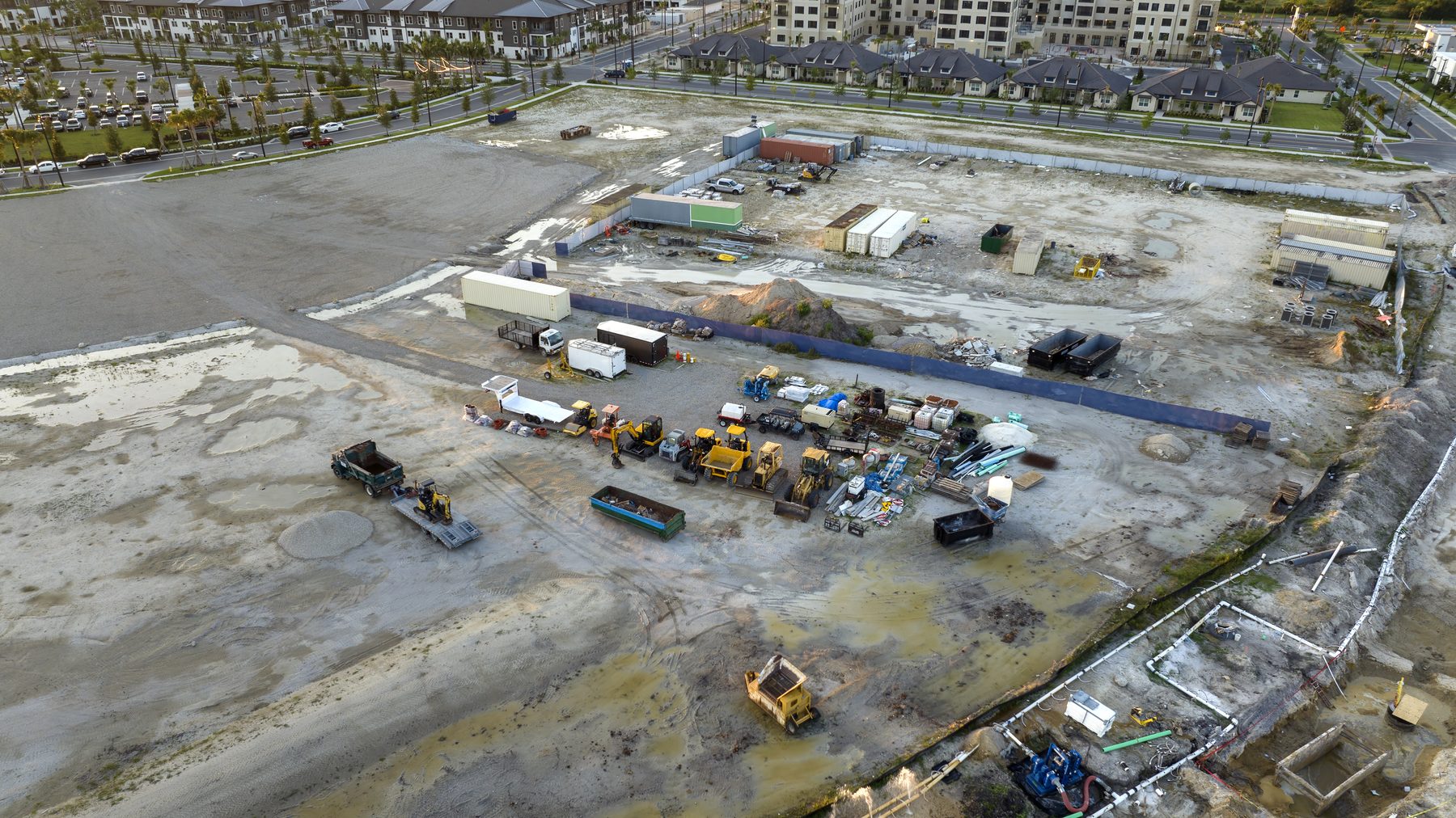 Aerial view of a large construction site with parked equipment and unfinished groundwork
